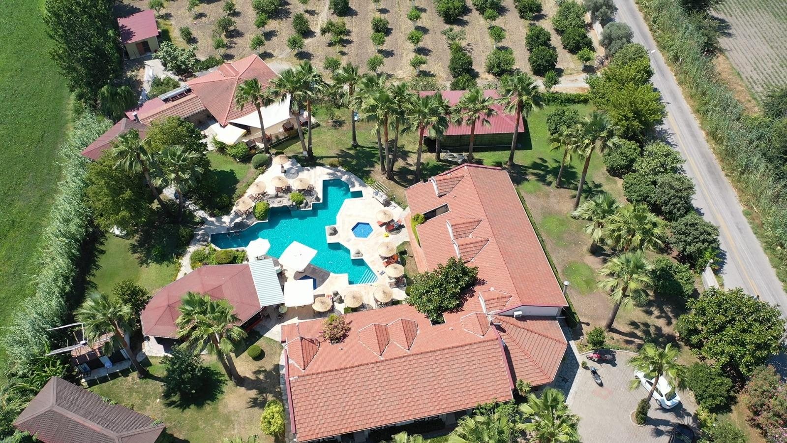 Luftaufnahme der Grenadine Lodge: Pool, Palmengarten und Felder am Rand von Dalyan